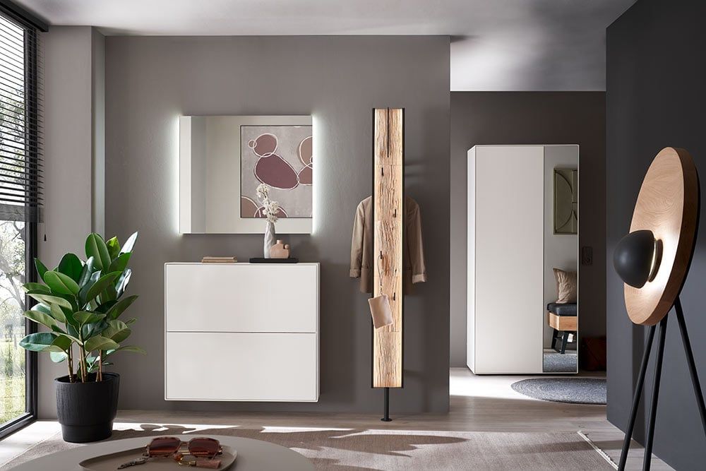 Flur mit Spiegel mit Licht, weißem Schuhschrank und Garderobenpaneel aus Holz