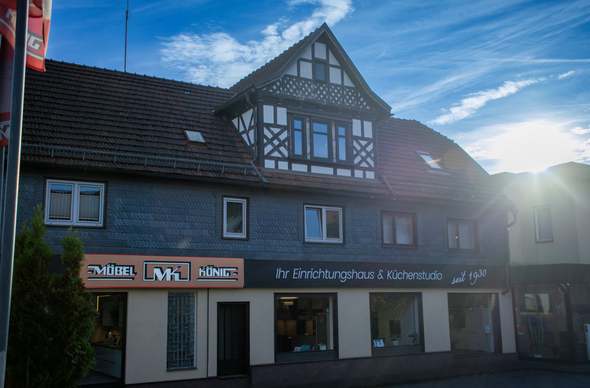 Möbel König in Steinbach-Hallenberg: Schieferhaus mit Fachwerkgiebel und dem Schriftzug „Ihr Einrichtungshaus & Küchenstudio seit 1930“