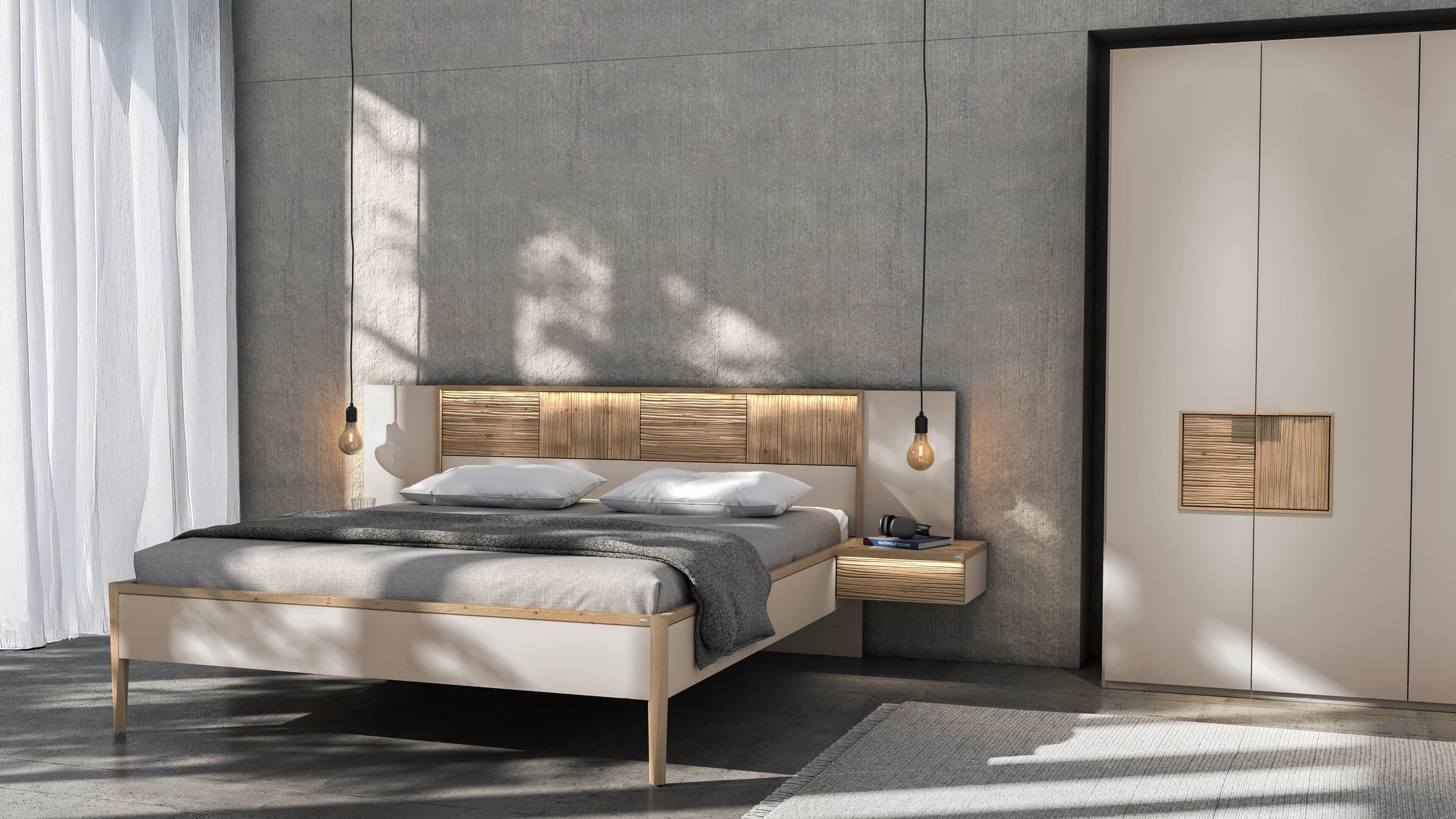 Bett mit Holzkopfteil und Hängeleuchten neben einem hohen Kleiderschrank in Creme