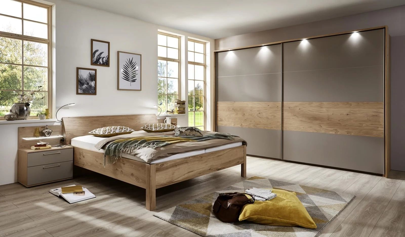 Helles Schlafzimmer mit Holzbett und großem Schwebetürenschrank in Grau und Eiche mit Beleuchtung