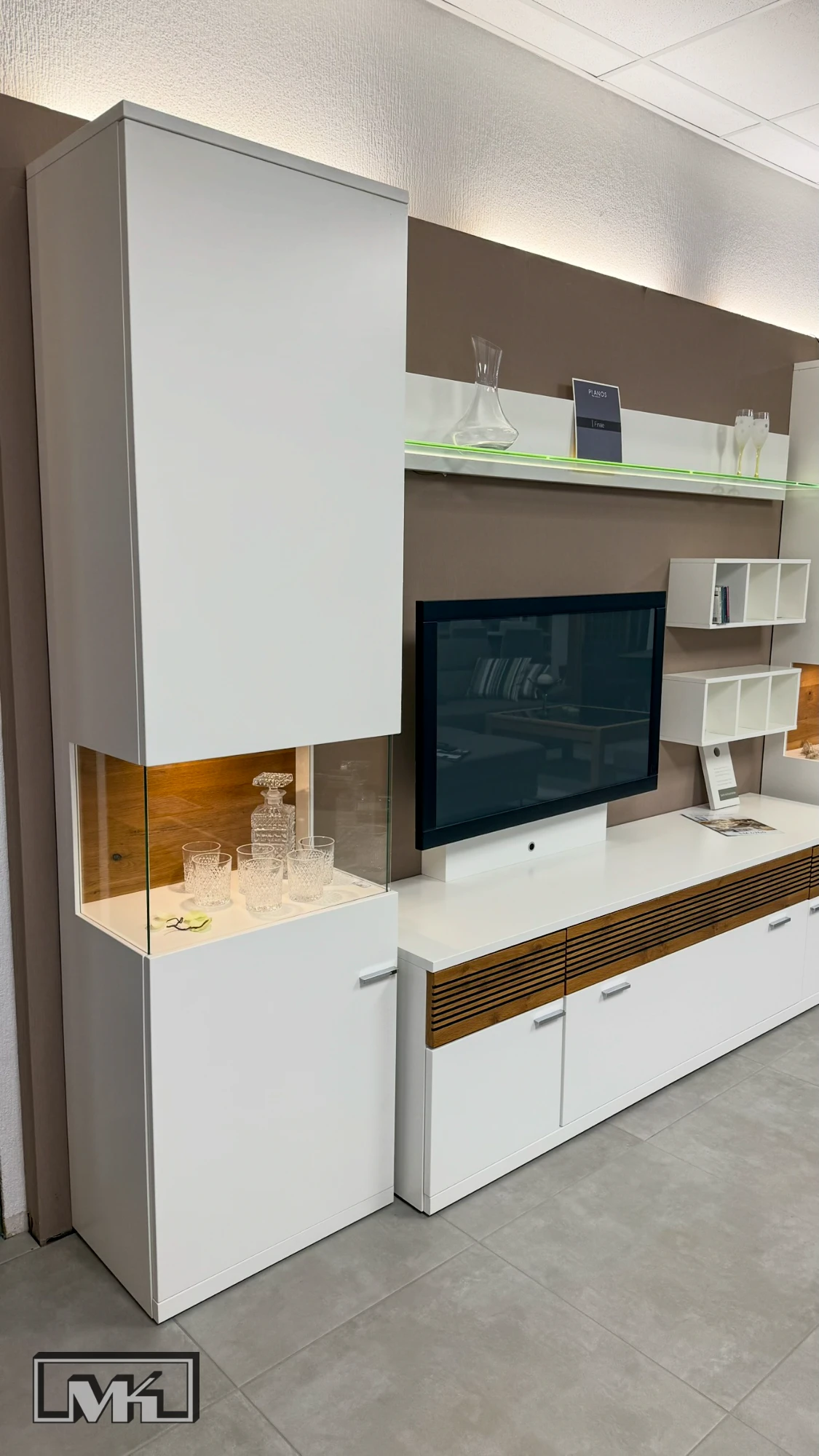 Linke Vitrine der Wohnwand Finale mit beleuchtetem Glasausschnitt und Eiche-Rückwand